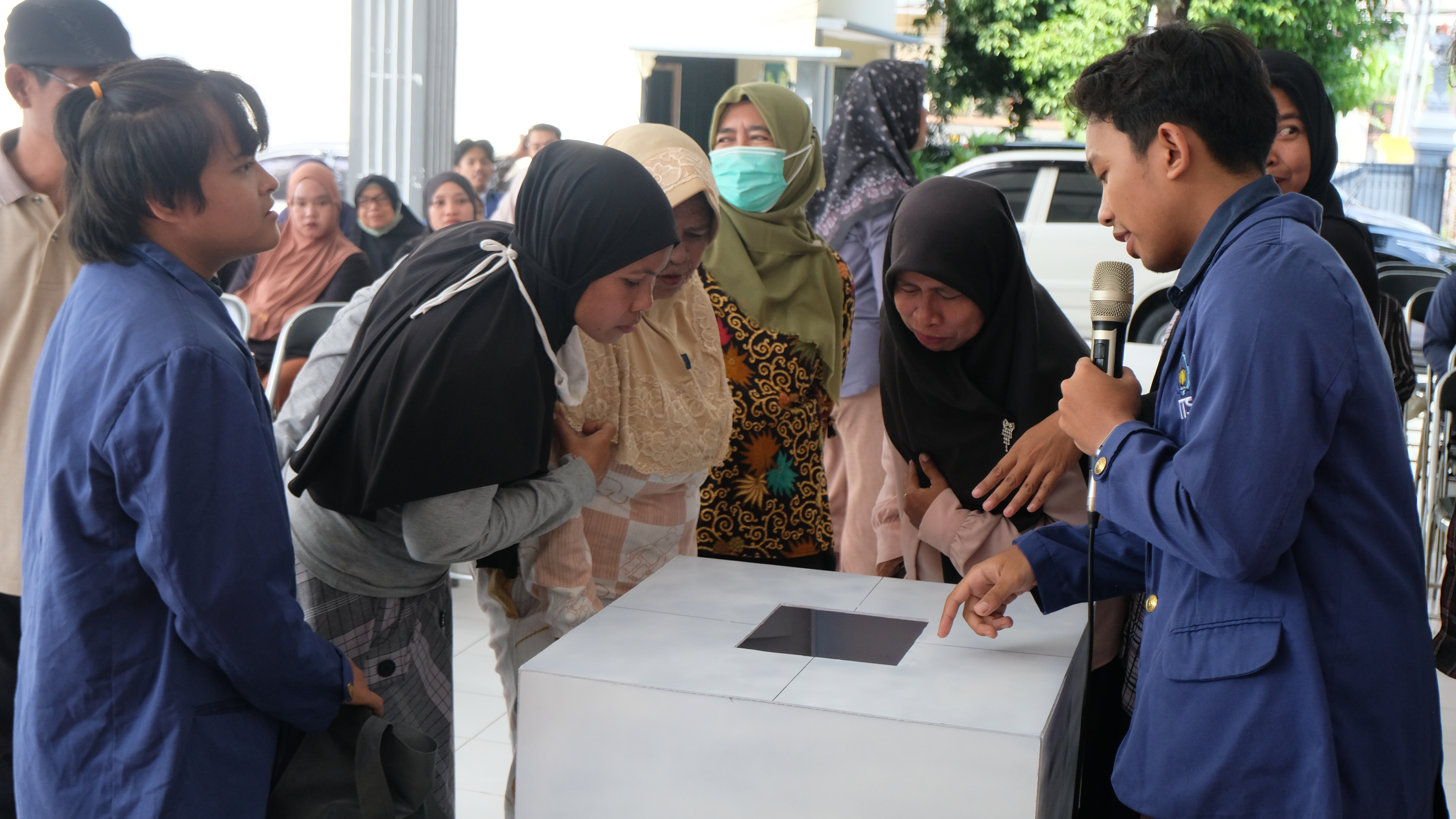 Foto Tim Smart Arundam (almamater ITS) saat mendemonstrasikan penggunaan tempat sampah sensorik pintar kepada masyarakat