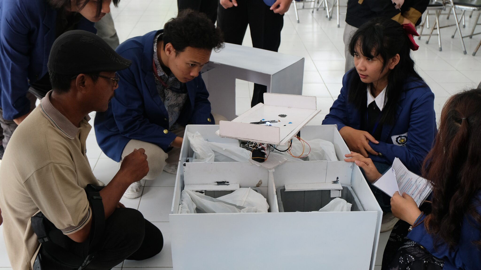 Foto Masyarakan Kelurahan Medokan Semampir (kiri) dan mahasiswa ITS saat berdiskusi terkait teknologi pemilahan sampah