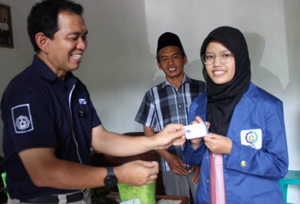 Kepala Departemen Teknologi Informasi ITS Dr techn Ir Raden Venantius Hari Ginardi MSc (kiri) menyerahkan Kartu Tanda Mahasiswa (KTM) kepada Maitasya Rohmatul Ula sebagai calon mahasiswa baru ITS