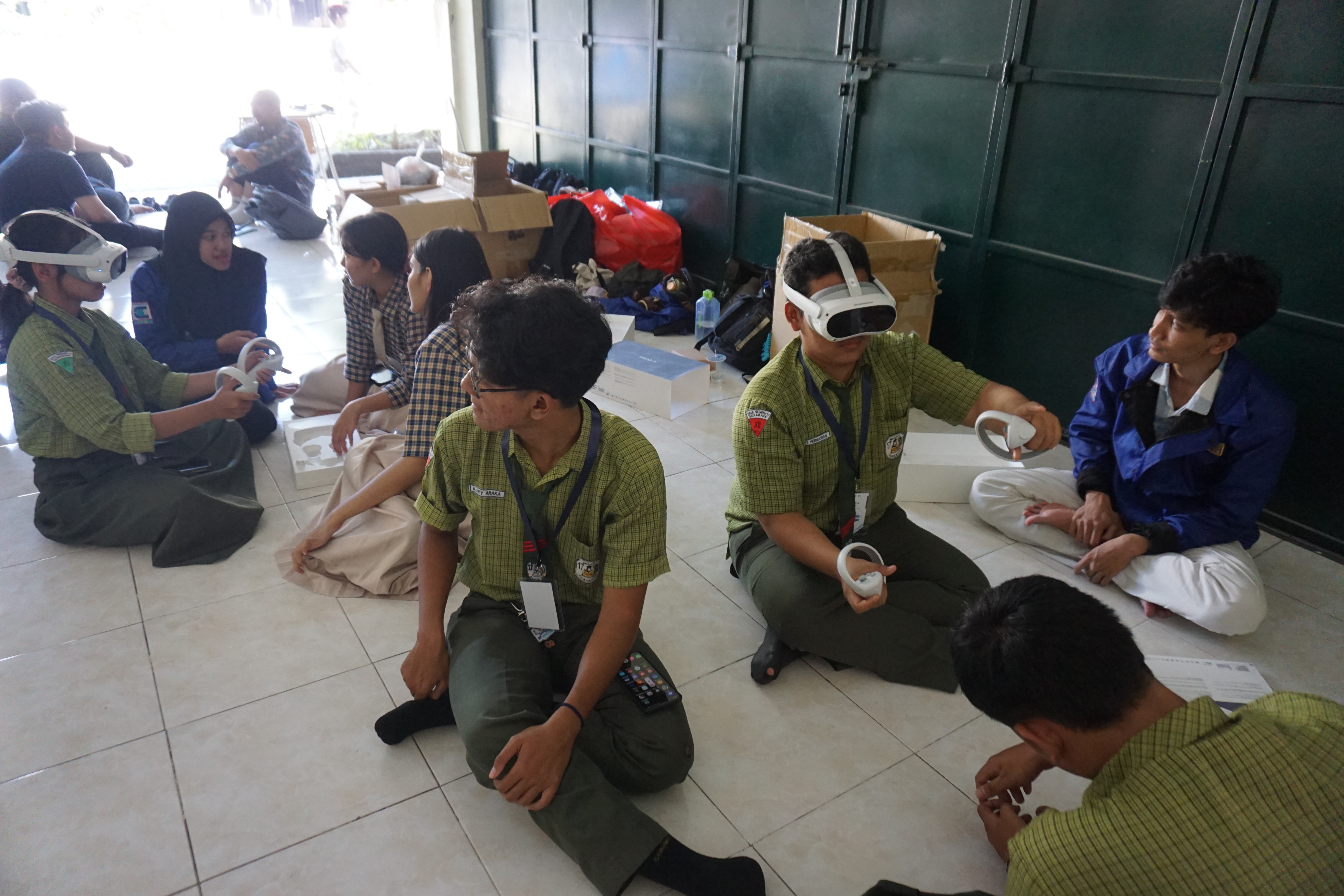Siswa SMA 17 Surabaya saat mencoba memainkan Virtual Reality (VR) didampingi oleh anggota tim KKN