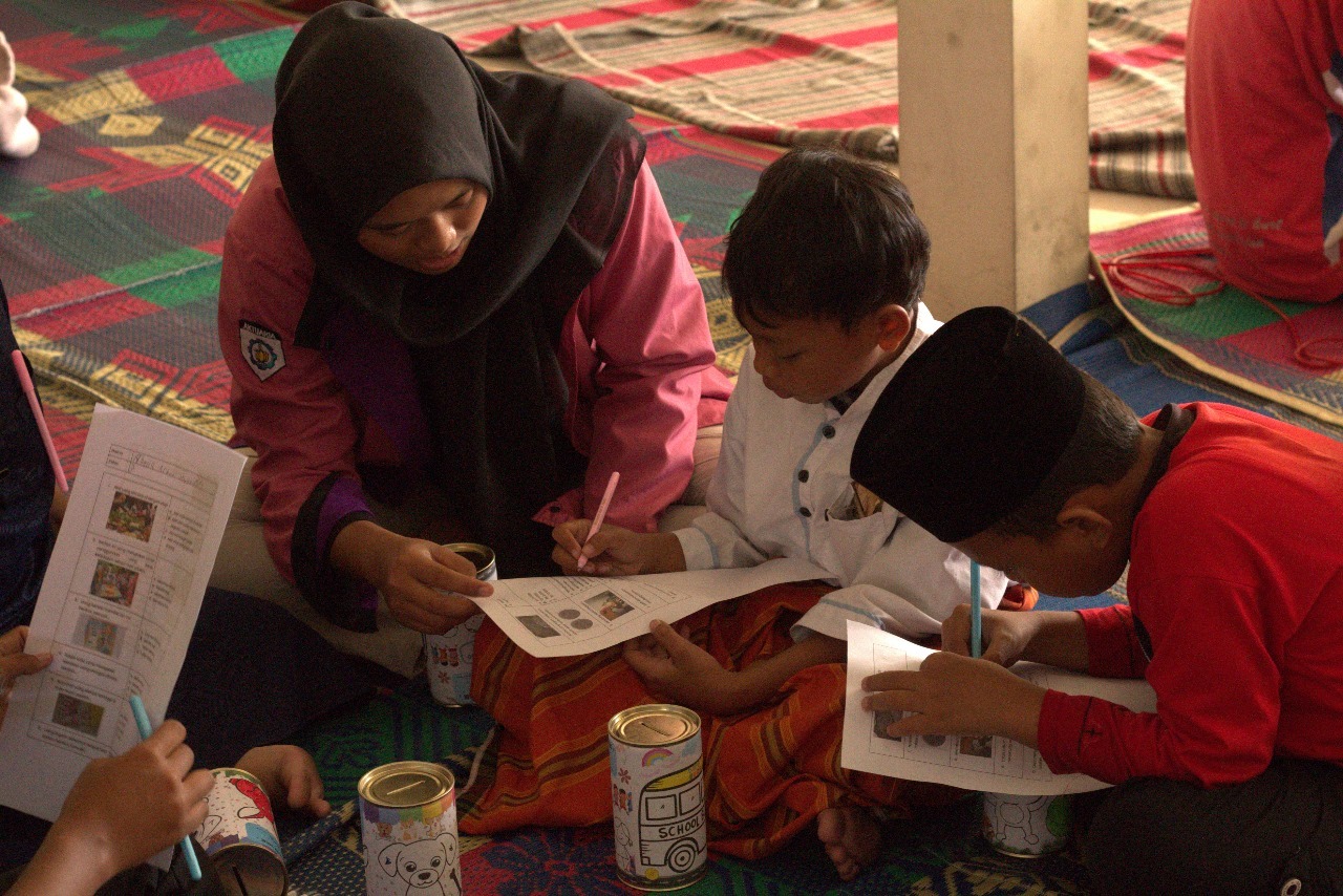Tim Abdimas saat memberikan pembelajaran seputar kebiasaan menabung untuk anak-anak SD