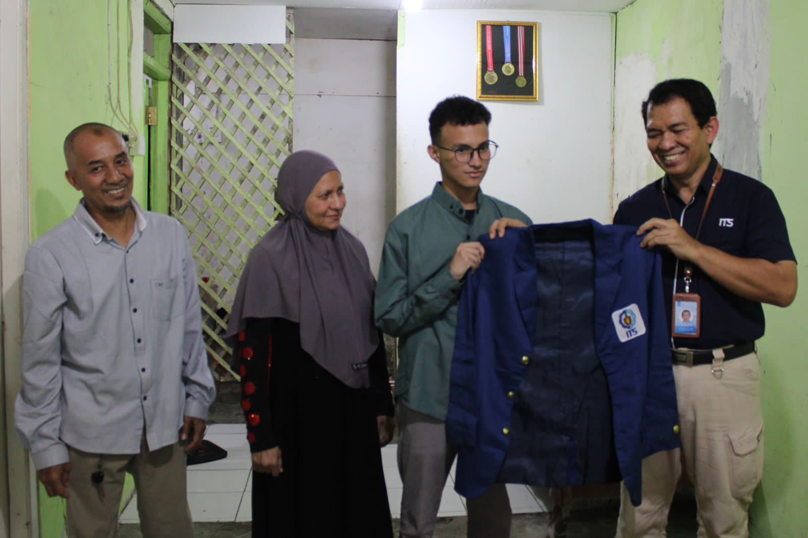 Umar (dua dari kanan) didampingi kedua orang tuanya menerima jas almamater ITS dari Kepala Departemen Teknologi Informasi ITS Dr techn Ir Raden Venantius Hari Ginardi MSc (kanan)