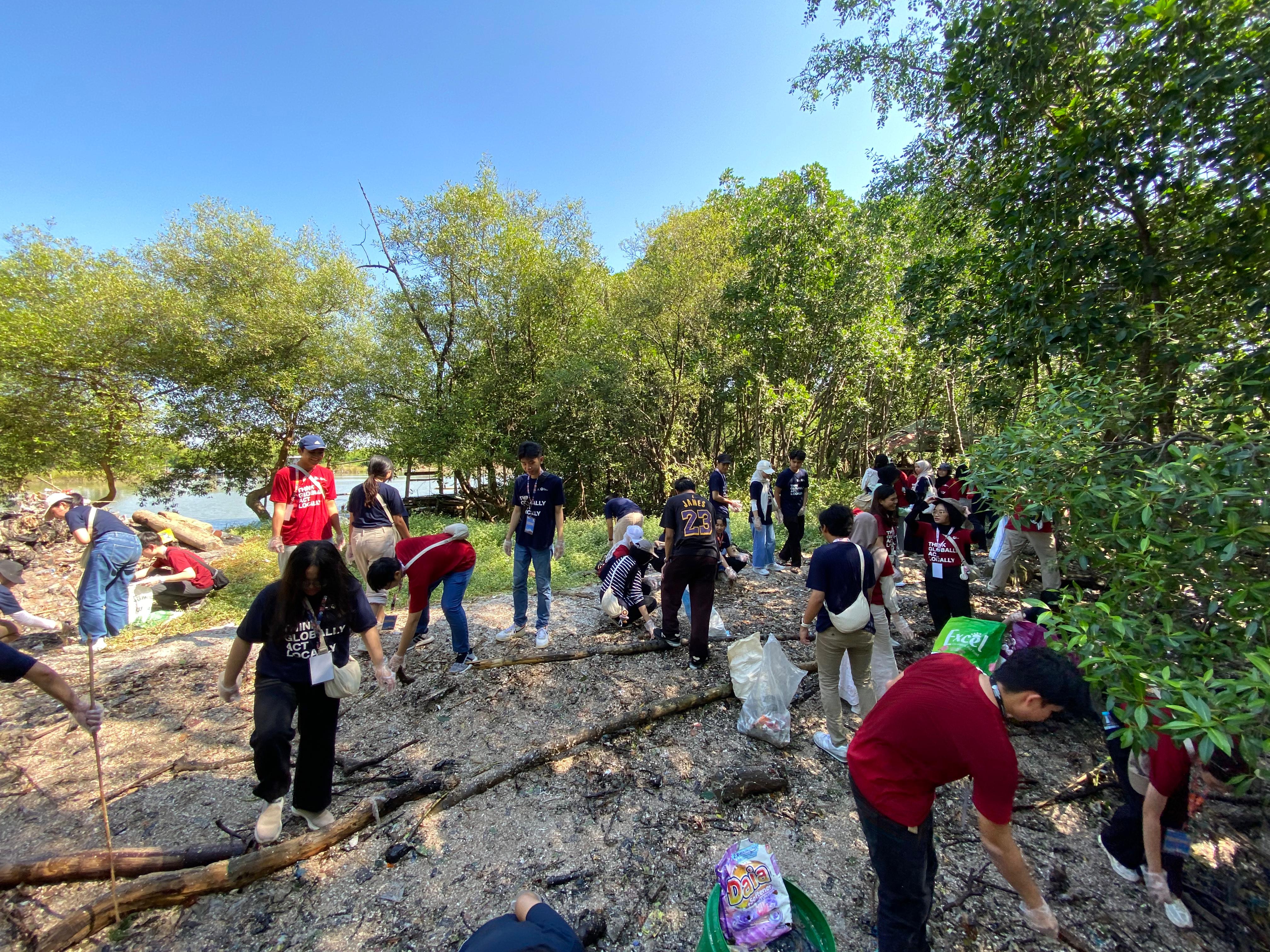 Gambar peserta NTU-INSPIRASI Summer Program membersihkan sampah di kawasan Hutan Mangrove Wonorejo, Surabaya