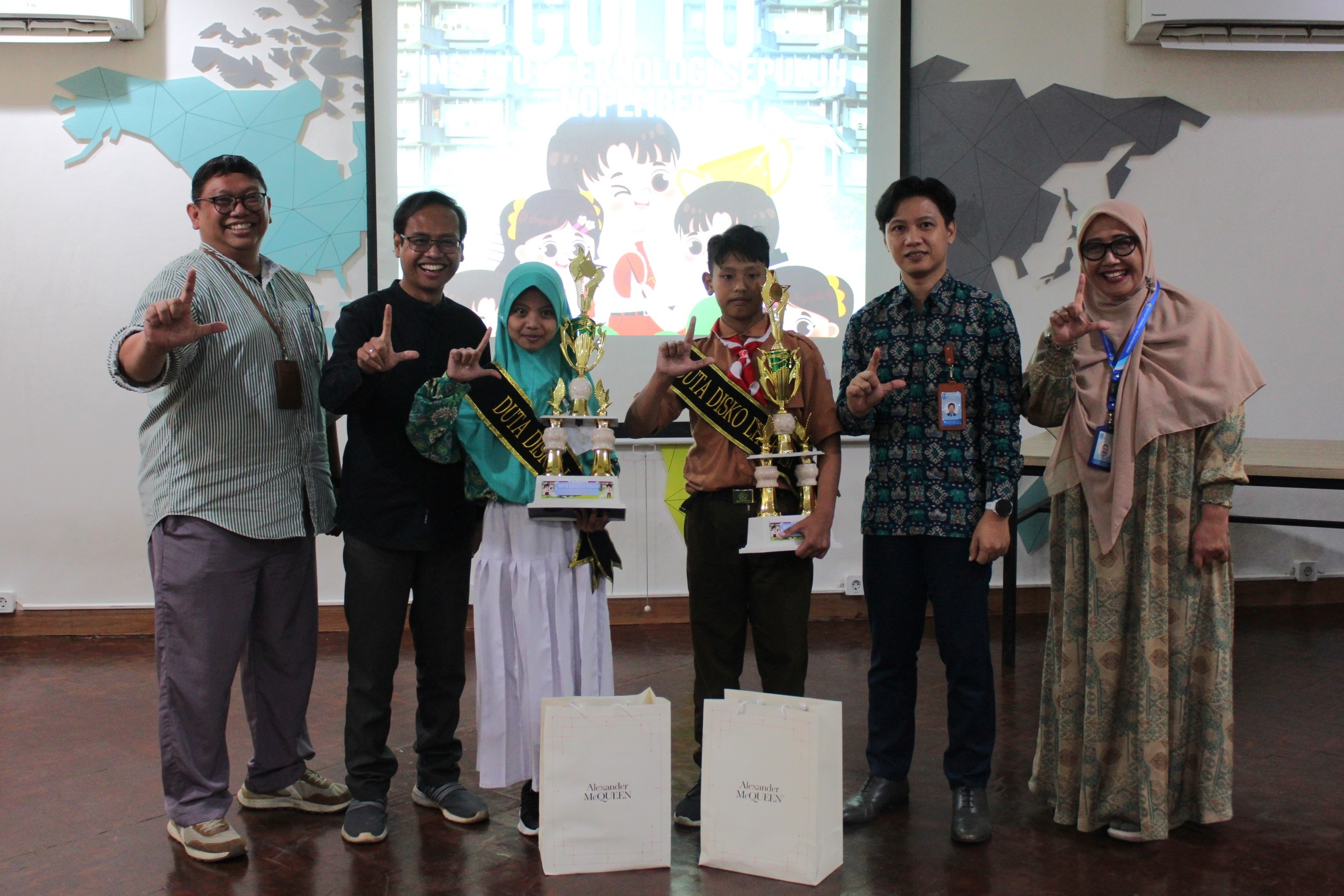 Dua siswa yang meraih predikat Duta Ilmu Sains Kreatif dan Orientatif (DISKO)(tengah memegang piala) Adibah Arum Rifdah siswi MI Tarbiyatus Sa’adah Gresik dan Ghiyas siswa dari MI Nashruddin Gresik