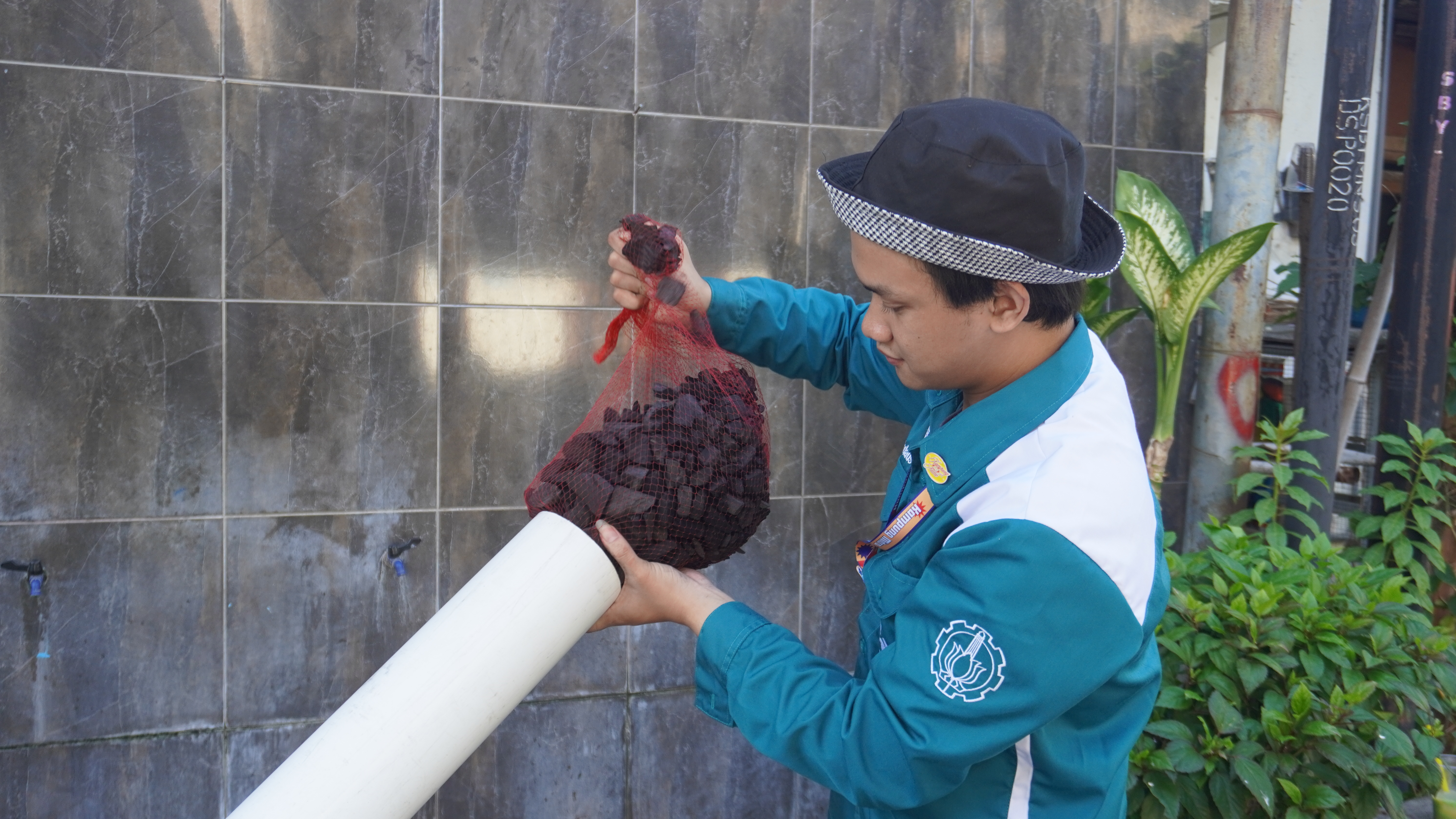 Foto Mahasiswa Teknik Lingkungan ITS saat melakukan instalasi filter air limbah pada gelaran Kammit 2025
