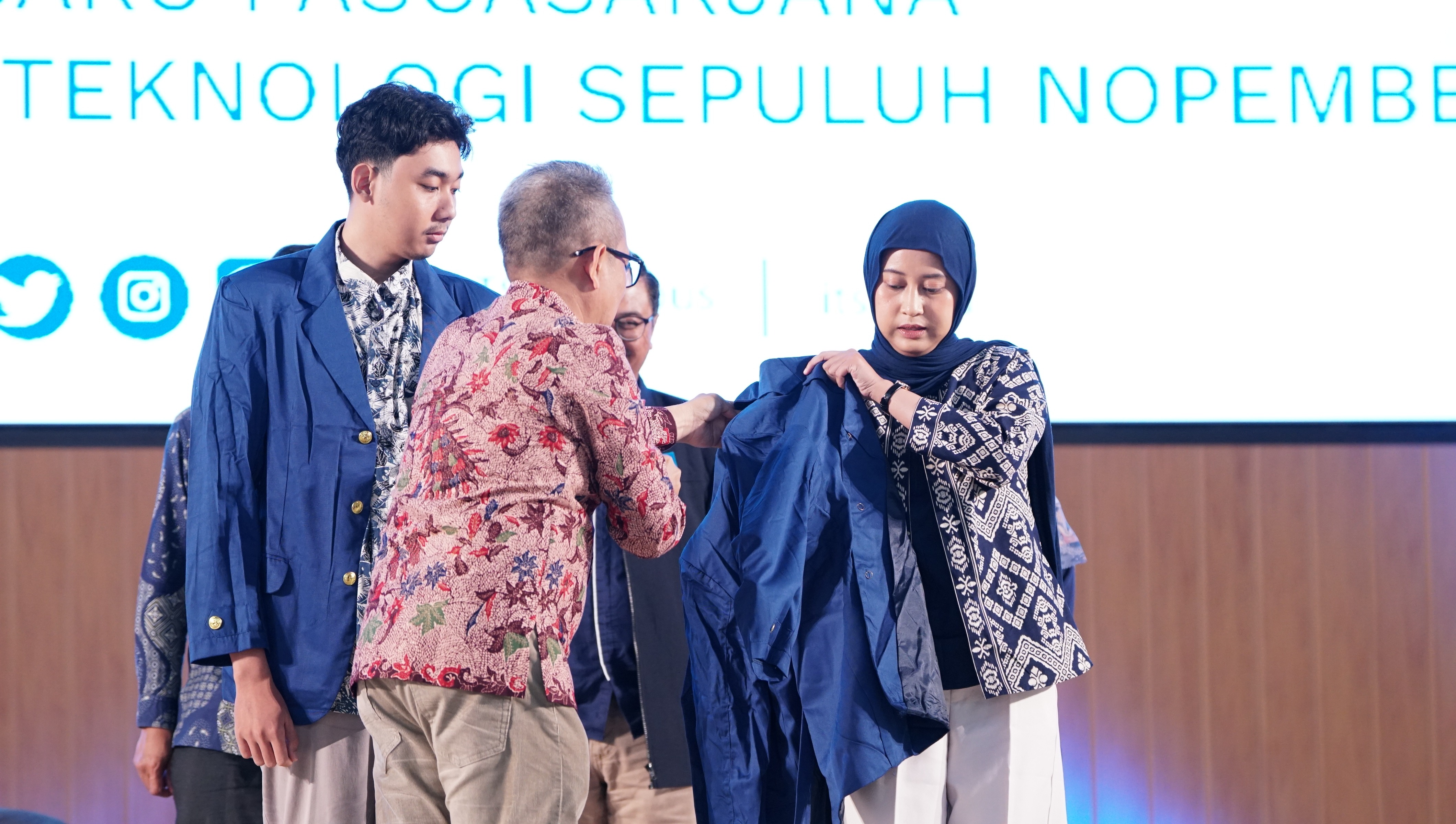 Gambar Wakil Rektor Bidang Perencanaan, Keuangan, dan Sarana Prasarana ITS Dr Machsus ST MT saat menyematkan jas almamater kepada dua perwakilan mahasiswa baru pascasarjana ITS