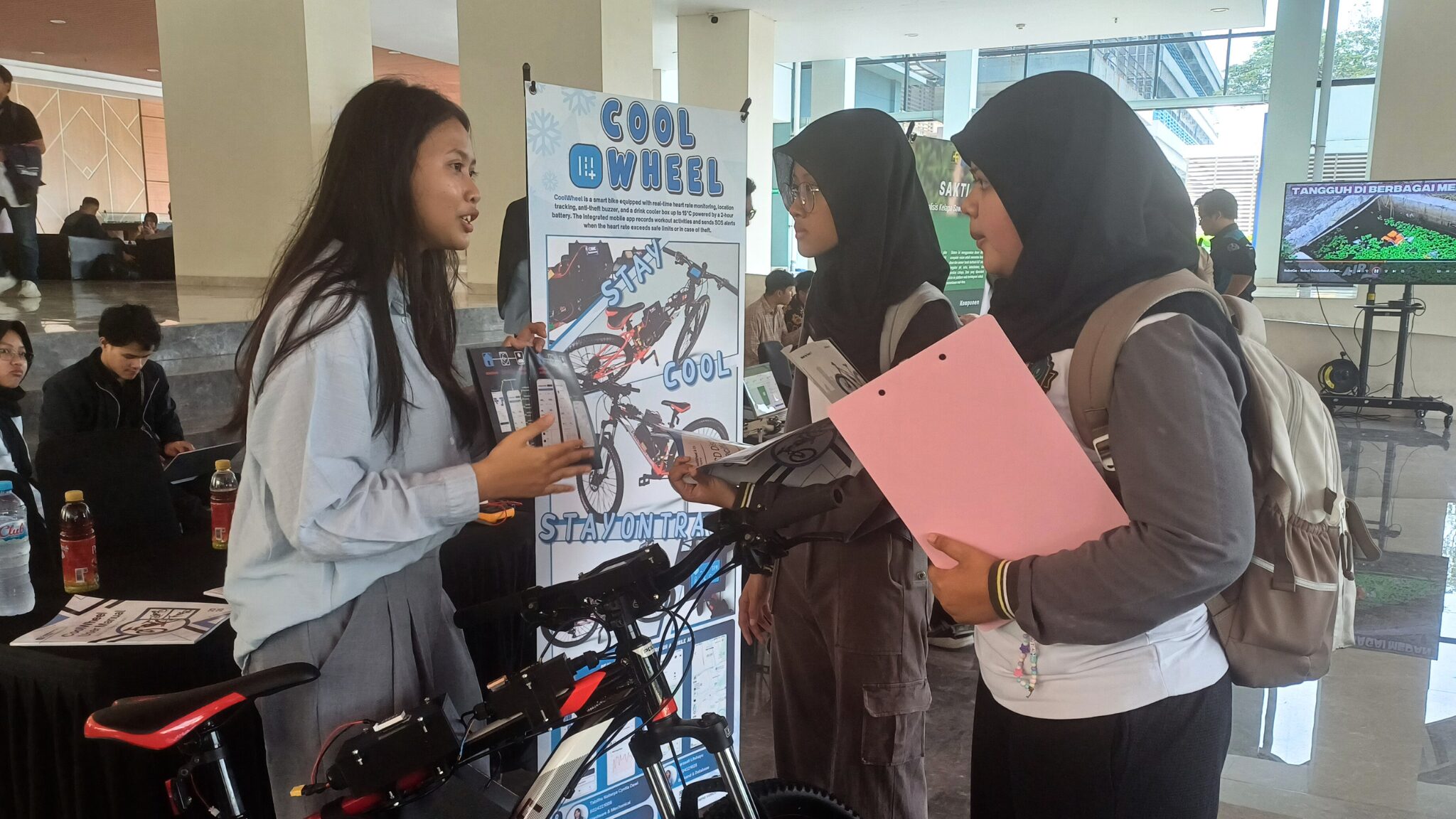 Foto Mahasiswa Teknik Komputer (kiri) saat menjelaskan inovasi Cool Wheel pada siswa SAIM Surabaya