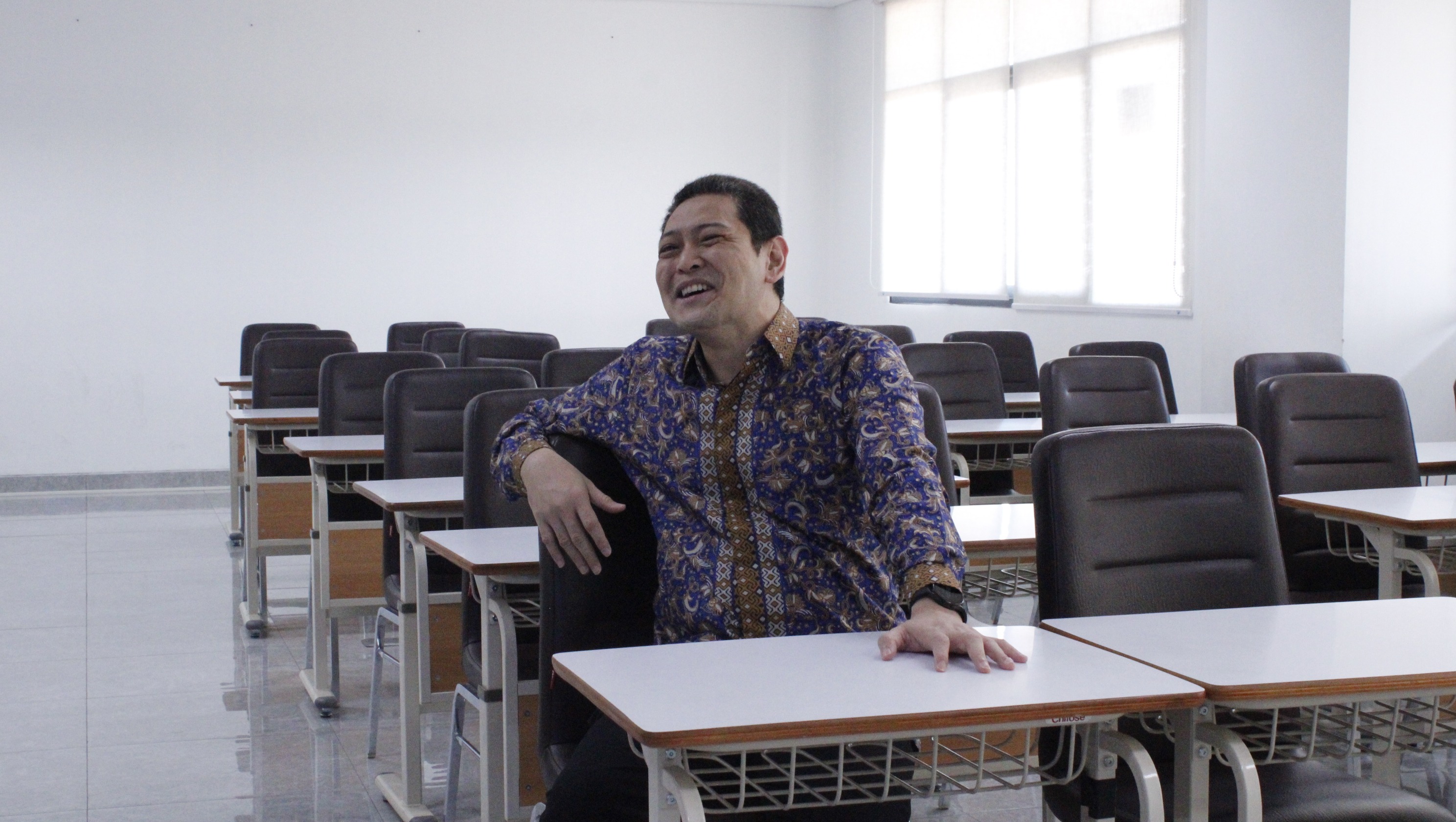 DrEng Steven Ray Sentinuwo ST MTI saat mencoba tempat duduk mahasiswa yang digunakan untuk kegiatan pembelajaran