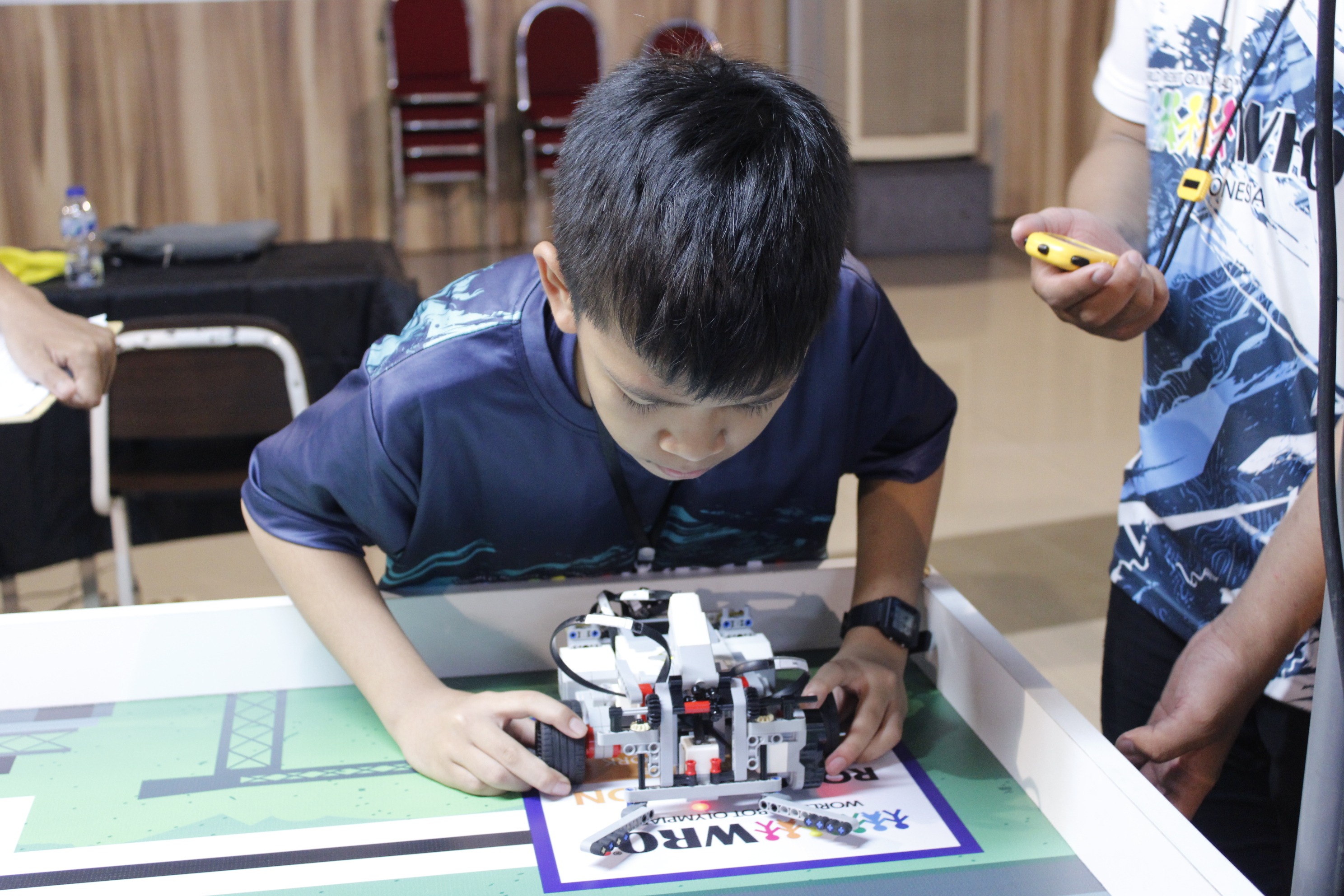 Gambar salah satu peserta Entry Level Robomission saat meletakkan robotnya pada arena perlombaan