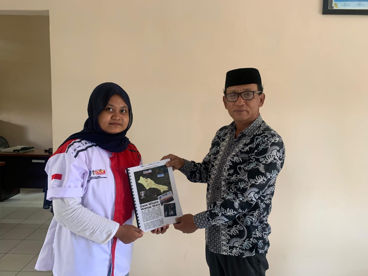 Foto Safia Melati Dewi Bersama Kepala Desa Wanua Waru saat Penyerahan Majalah di Kantor Desa Wanua Waru, Minggu (27/07/2025)
