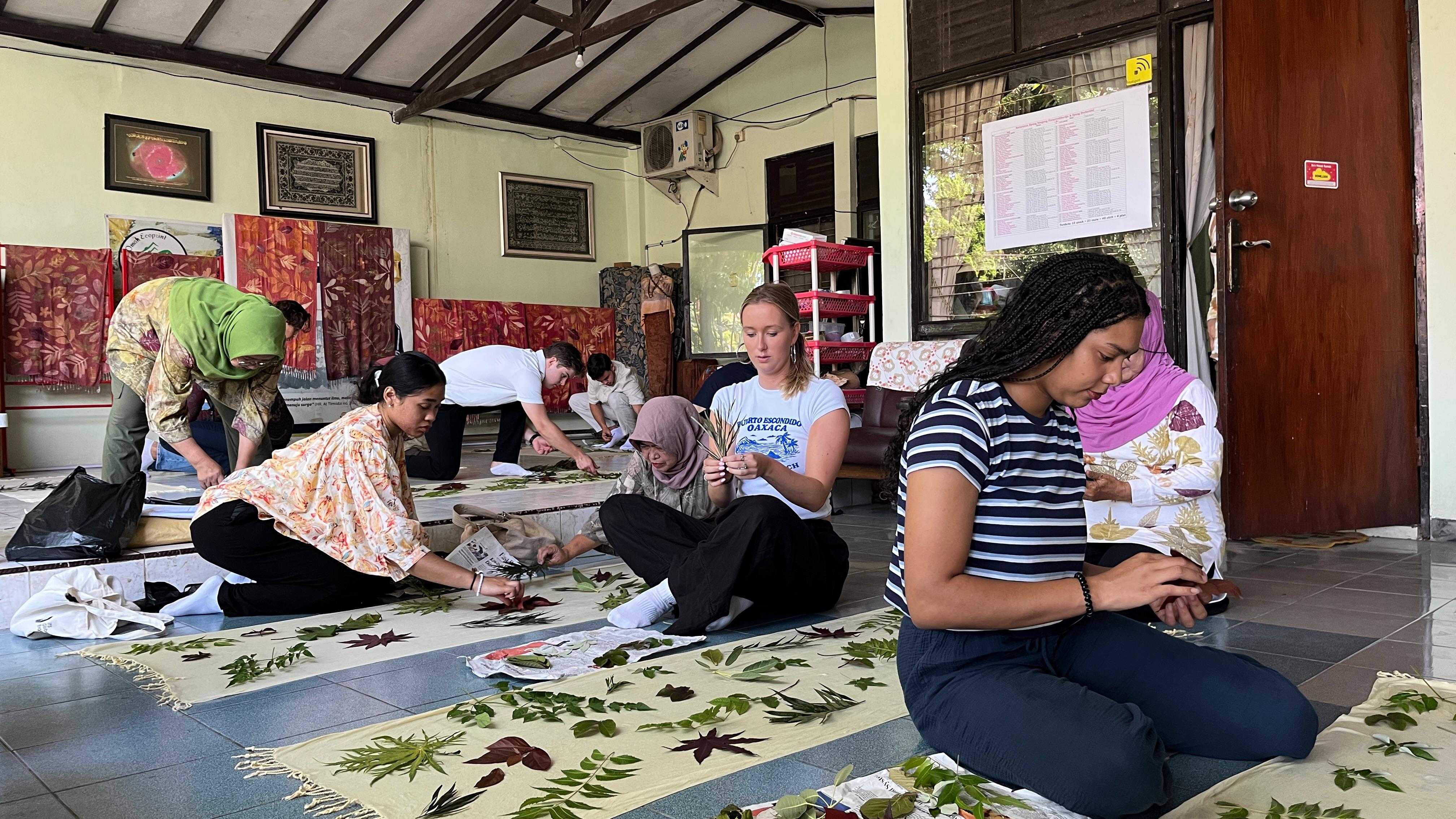 Para mahasiswa asing dari Universitas HU menyusun pelepah daun saat proses ecoprint bersama dengan para anggota Omah Ecoprint