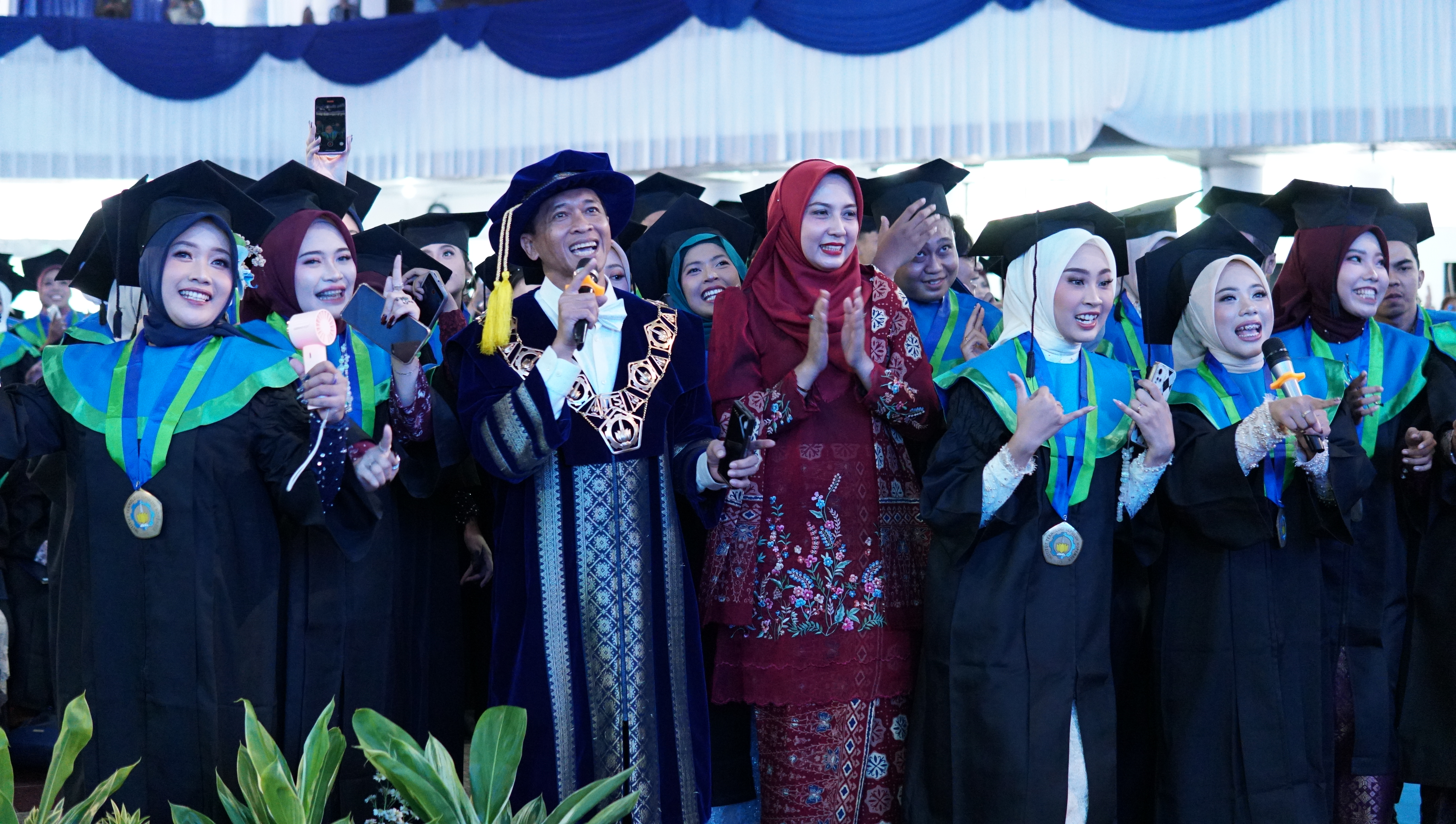 Gambar Rektor ITS Prof Ir Bambang Pramujati ST MScEng PhD bersama istri dan wisudawan ITS ketika bernyanyi dan bergoyang bersama dalam lantunan lagu Tabola Bale di prosesi Wisuda ke-132 ITS