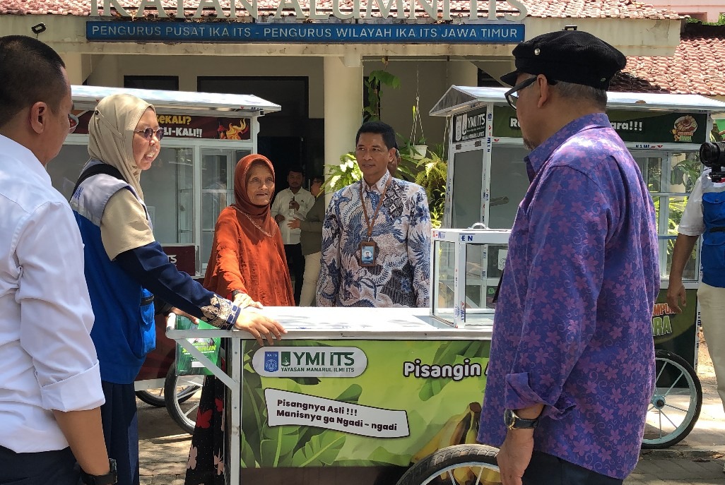 Rektor ITS Prof Ir Bambang Pramujati ST MSc Eng PhD (dua dari kanan) saat menyerahkan rombong usaha kepada Mun (tiga dari kiri), penjual pisang di kawasan Gebang, Surabaya