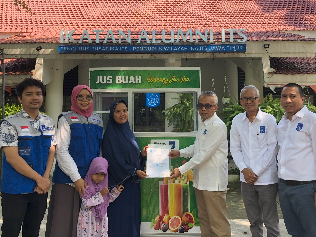 Wakil Rektor II ITS Dr Ir Machsus ST MT (tiga dari kanan) bersama perwakilan YMI dan IKA ITS saat serah terima bantuan rombong kepada Wiwin (berjilbab biru)