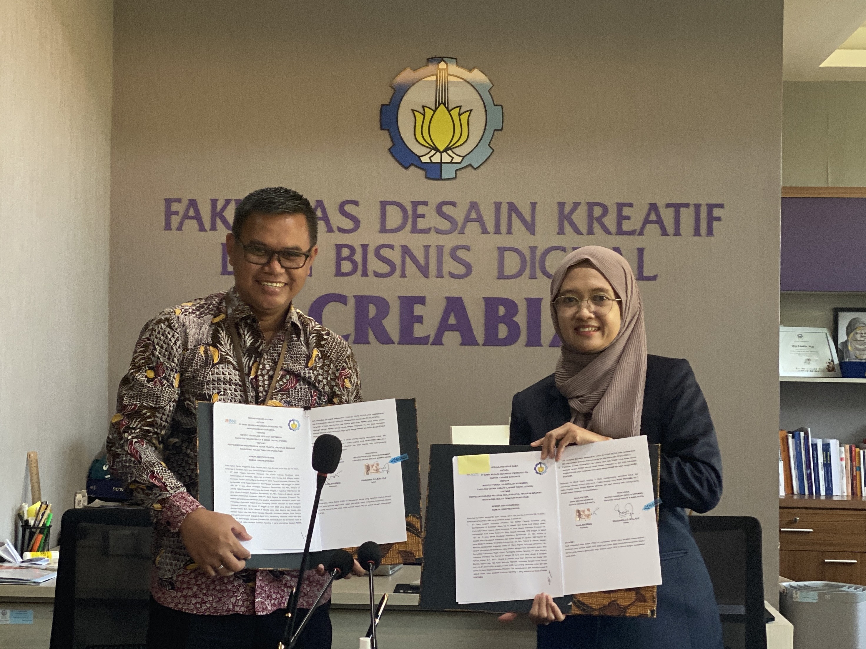 Pimpinan BNI Kantor Cabang Surabaya Kurnia Andi Wijaya (kiri) dan Dekan FDKBD Ellya Zulaikha ST MSn PhD menunjukkan naskah PKS yang telah ditandatangani