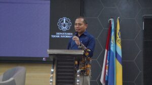 Ketua Pelaksana Pelatihan 1.000 Duta AI 2025 Prof Dr I Ketut Eddy Purnama ST MT sedang memaparkan laporan mengenai kegiatan yang dilaksanakan