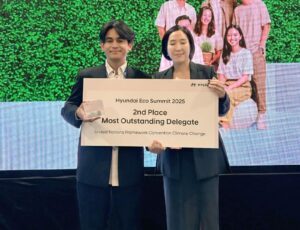 Aldiez Rizkia Centrinova (kiri) saat menerima penghargaan dari Chang Haelim selaku Vice President Hyundai Manufacturing Motor Indonesia