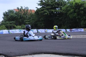 Gokart listrik dari tim Hyperblast V2 Politeknik Negeri Semarang (kiri) berusaha menyalip tim TMS Universitas Indonesia Motorsport di Sirkuit ITS