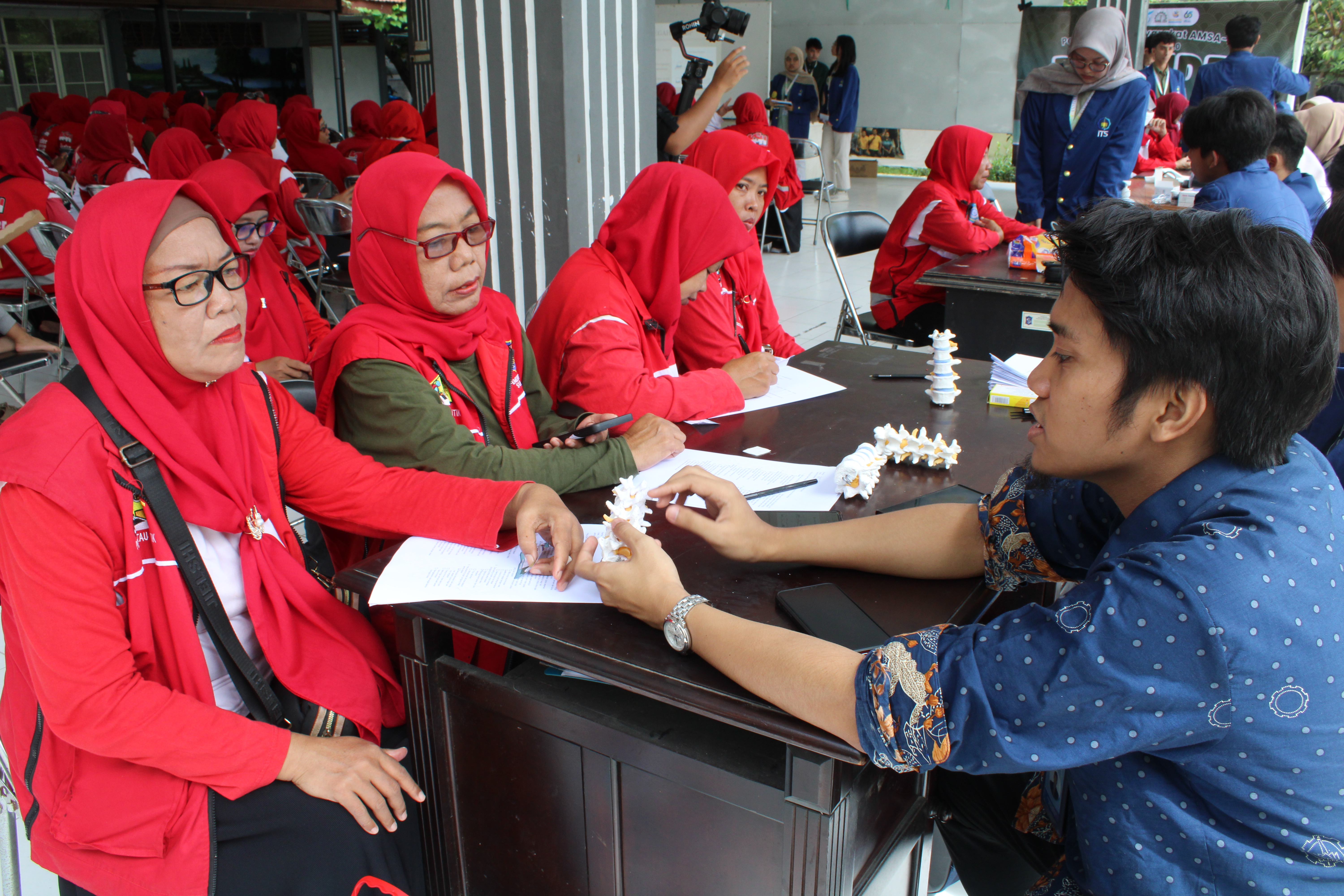 Gambar Dosen Pembina Abmas dr Gumilar Fardhani Ami Putra MBiomed (kanan) menjawab permasalahan kesehatan salah satu Kader Surabaya Sehat (kiri) dalam pemeriksaan kesehatan pada gelaran Promoting Spine Health Through Understanding and Real Education (Posture)