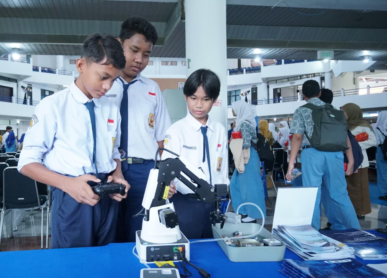Para siswa SMP terlihat antusias ketika mencoba salah satu alat inovasi karya mahasiswa Departemen Teknik Telekomunikasi ITS yang turut dipamerkan