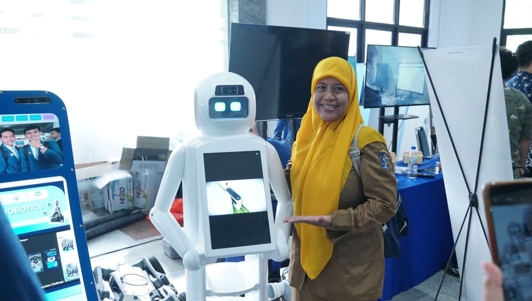 Salah satu guru bersama robot pintar RAISA Humanoid karya inovatif ITS yang unjuk aksi dalam kegiatan AI Talent and Innovation Day 2025