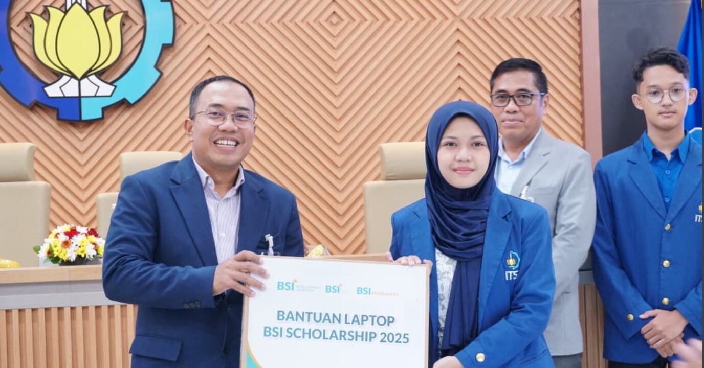 Regional CEO Region 8 Surabaya BSI Jajang Abdul Karim (kiri) menyerahkan bantuan laptop secara simbolis kepada salah satu penerima beasiswa Belgis Alfiana Nurotul Qolbi