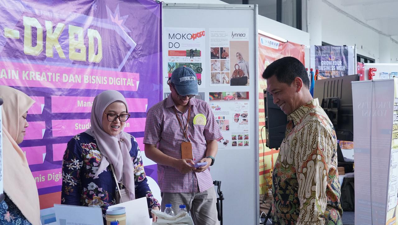 Rektor ITS Prof Dr (HC) Ir Bambang Pramujati ST MSc Eng PhD (kanan) saat mengunjungi stan pameran Fakultas Desain Kreatif dan Bisnis Digital (FDKBD) ITS dalam kegiatan Ini Lho ITS 2026 di Grha Sepuluh Nopember ITS