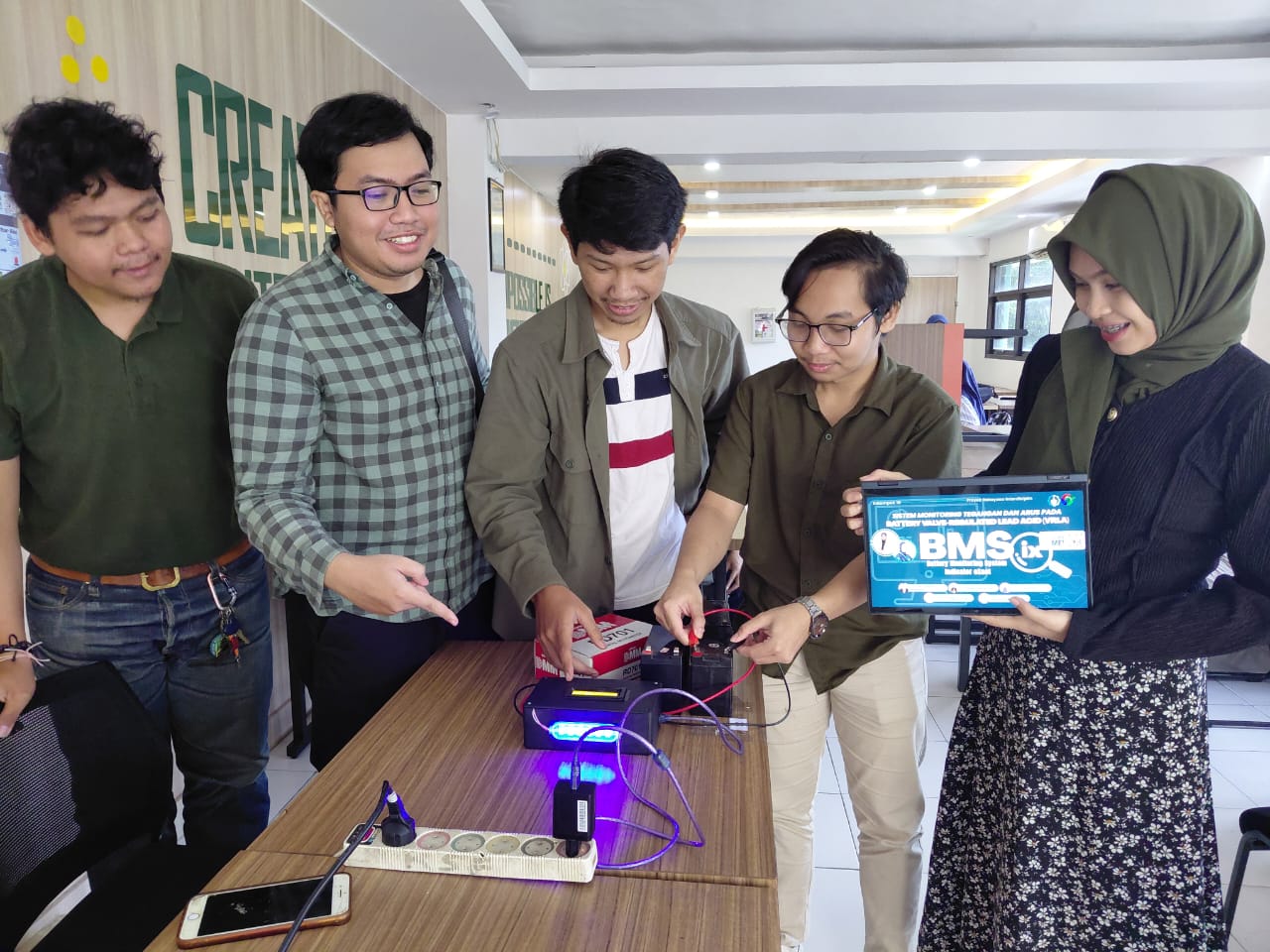 Arya William beserta rekan-rekan memamerkan proyek sistem monitoring baterai timnya