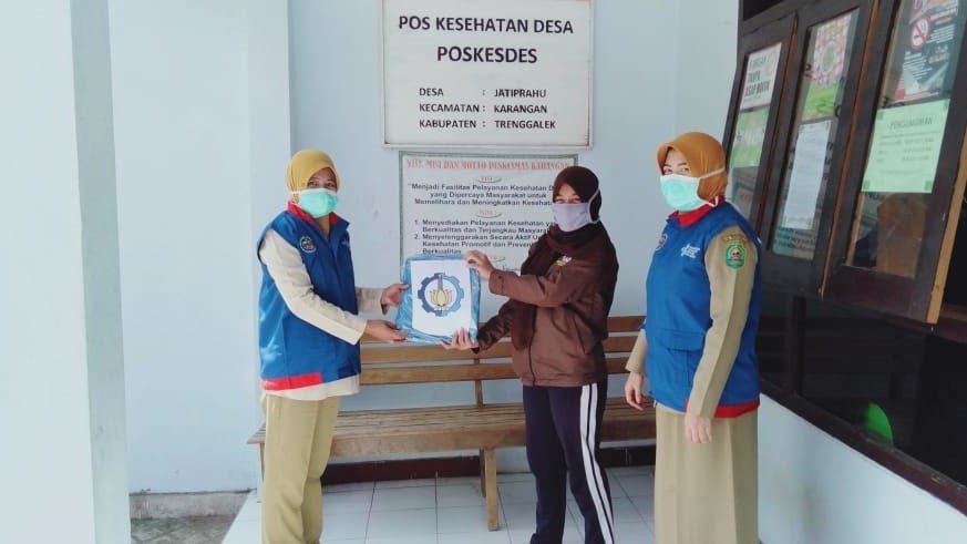 Novie Wahyu Dhanayani, Student of Departement of Urban and Regional Planning Department ITS (center) while providing the help of the hazmat clothes on Pokesdes Jatiprahu