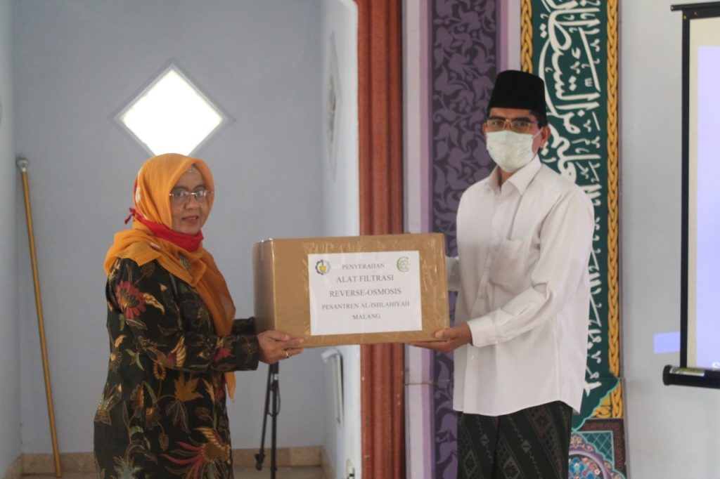 Prof Dr Fahimah Martak MSi (kiri) memberikan bantuan alat penjernih air secara simbolis kepada pengurus Pondok Pesantren Al-Ishlahiyah