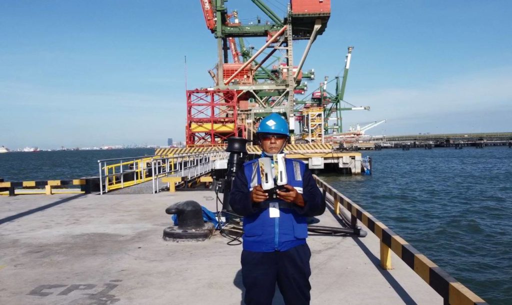Unggun Dahana dari program magister Departemen Teknik Sistem Perkapalan ITS, wisudawan tertua pada Wisuda ke-124 ITS, saat sedang memantau laut menggunakan drone di pelabuhan