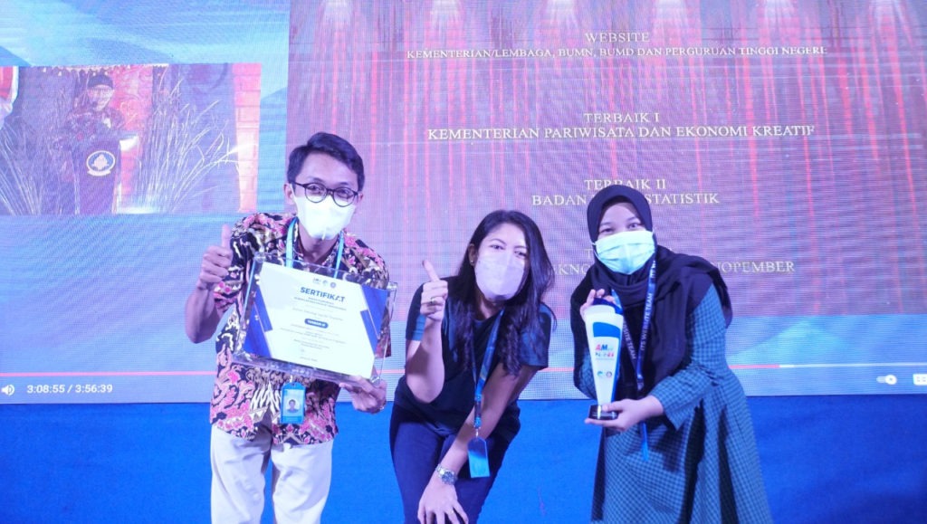 Putri Dwitasari ST MDs (tengah) diapit oleh koordinator pengelola website ITS, Tommy Nuril Hudha (kiri) dan Nurina Azyyati Riski (kanan) menunjukkan piala dan penghargaan Terbaik 3 Website
