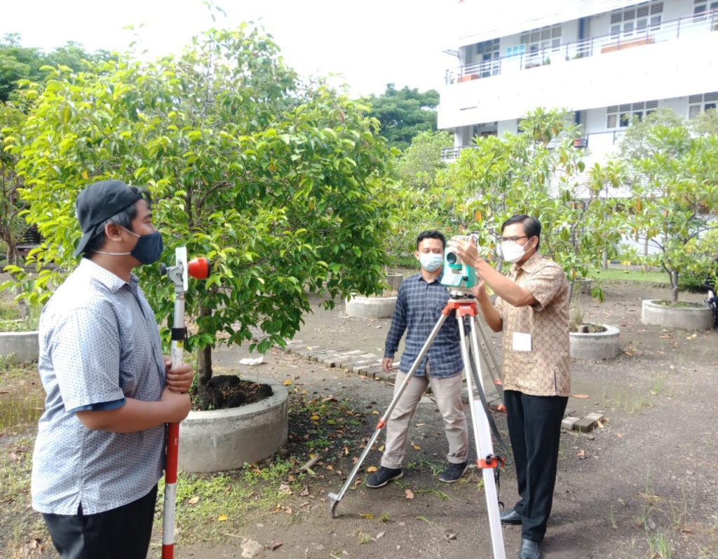 Lalu Muhamad Jaelani ST MSc PhD (berbatik) bersama tim mahasiswa ITS saat menyiapkan total station dan reflektor yang akan dibawa ke lokasi