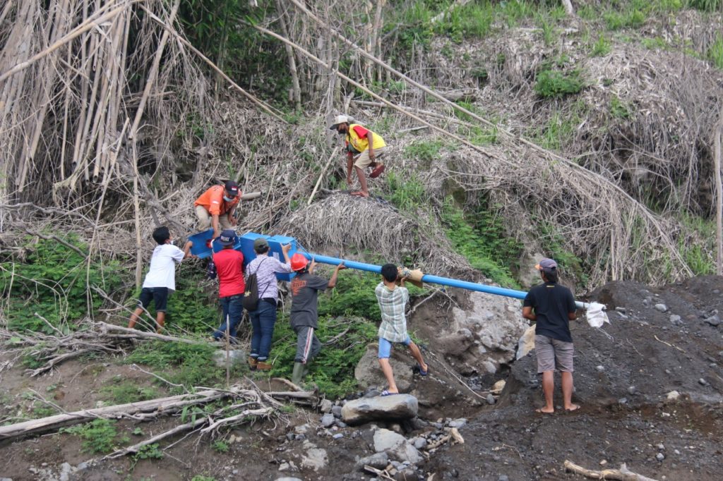 Proses pemasangan Early Warning System di kawasan Gunung Semeru dengan bantuan relawan setempat