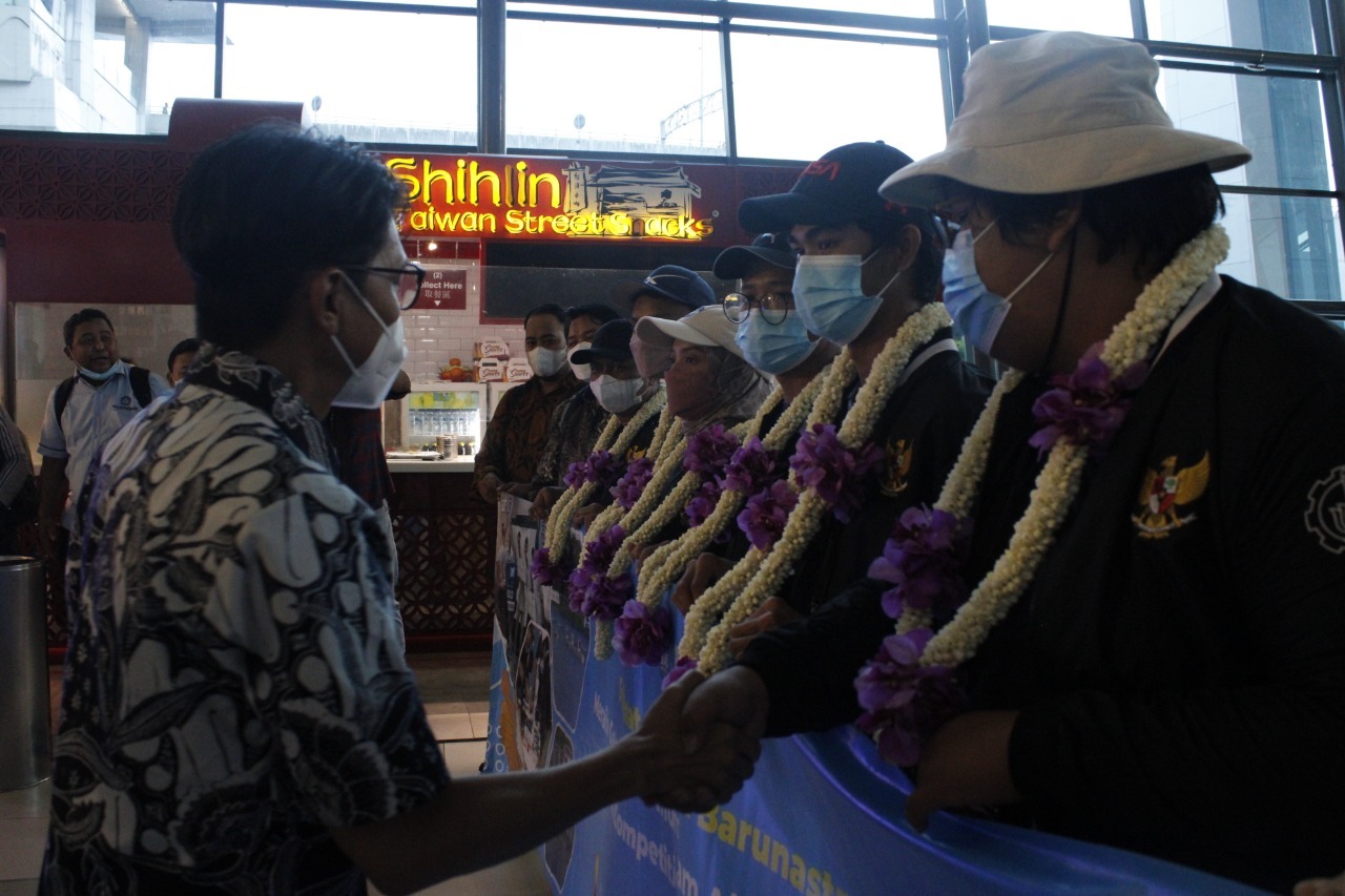 Plt. Kepala Puspresnas Asep Sukmayadi (kiri) memberikan apresiasi pengalungan bunga kepada Tim Barunastra ITS yang baru tiba di Bandara Internasional Soekarno-Hatta