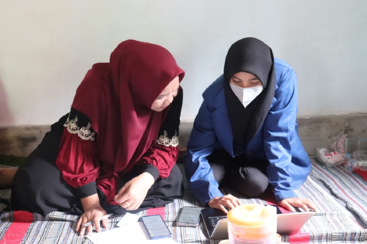 Salah satu mahasiswa tim KKN Abmas ITS (kanan) saat melakukan validasi data dalam pengisian berkas sertifikat halal pada pelaku UMKM di Kediri