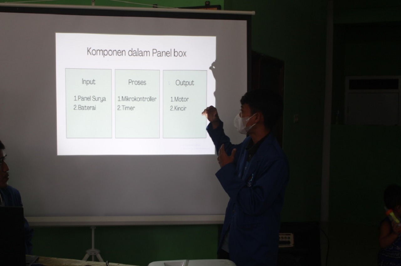 Salah satu mahasiswa anggota tim KKN PM ITS sedang memberikan penjelasan mengenai aerator di hadapan para petani dan warga di Balai RW Desa Gunung Anyar Tambak, Surabaya