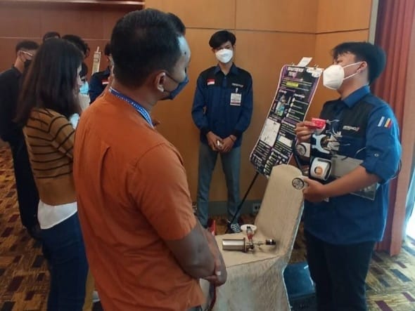 Dheas Pinda (menghadap kamera) bersama Wiji Dharma (kanan) memamerkan Chem E-Car kebanggaan tim Spektronics Nitro ITS di ajang Malaysia Chem-E-Car