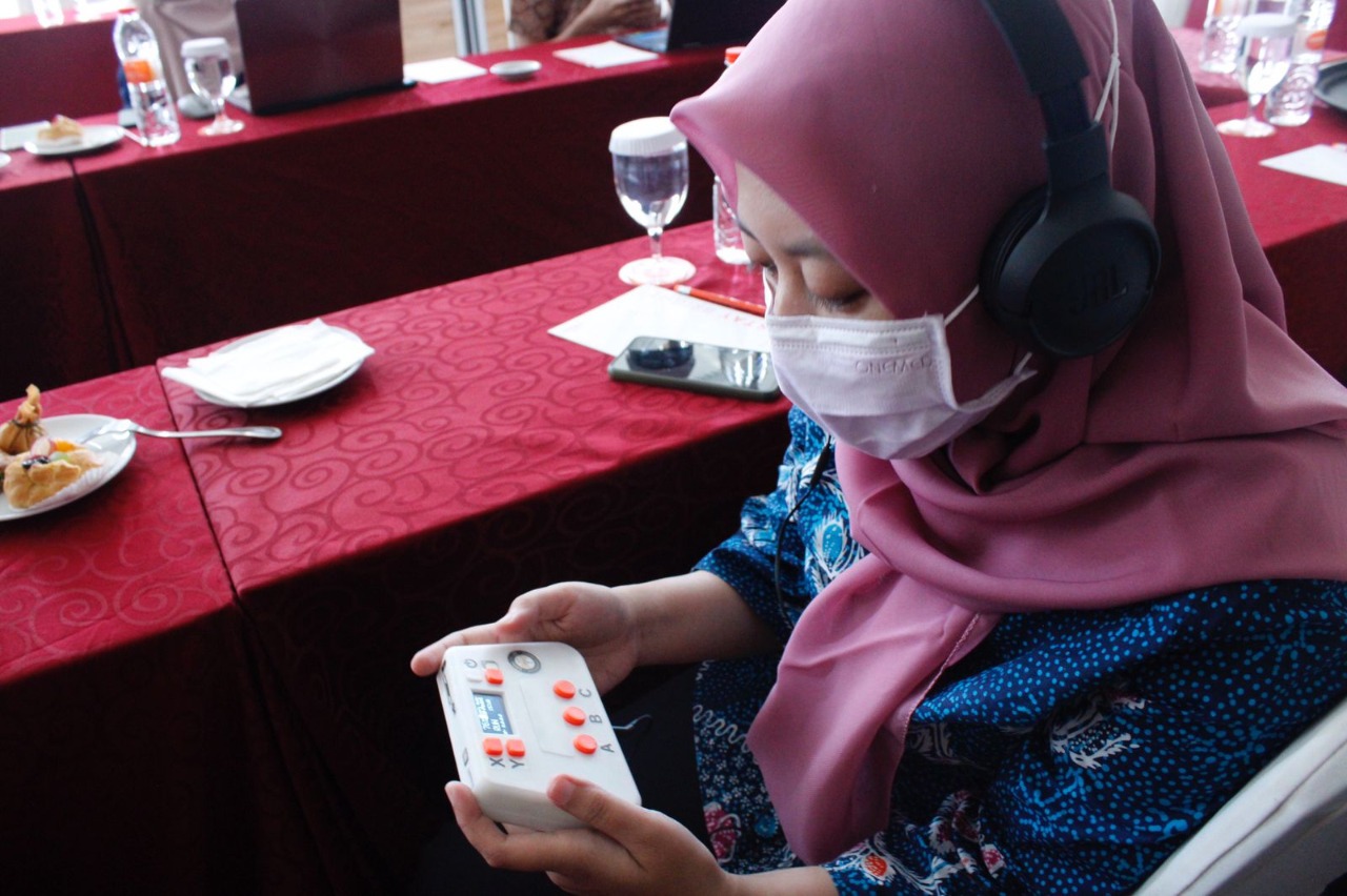 One of the representatives from the Faculty of Medicine of Airlangga University doing a hearing test using portable audiometry