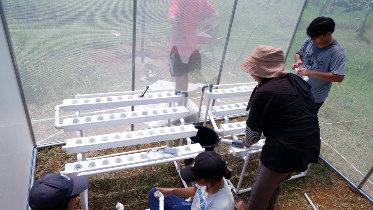 Perakitan peralatan hidroponik dalam greenhouse oleh tim Abmas ITS