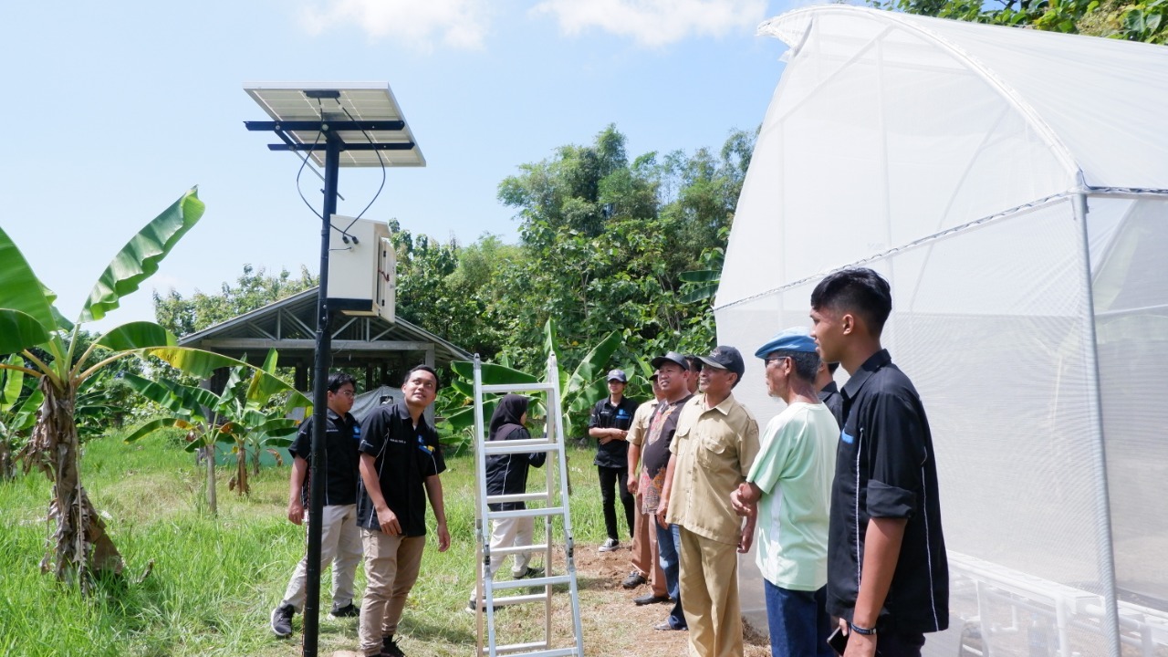Tim Abmas ITS saat memberikan sosialisasi langsung di lokasi pemasangan greenhouse kepada warga dan perangkat desa setempat