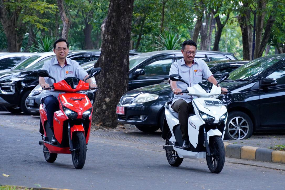 The Rector of UTM, Prof. Datuk Dr. Ahmad Fauzi Ismail (left) with one of his delegations while trying to ride GESITS, an electric motorcycle made by ITS academicians. 