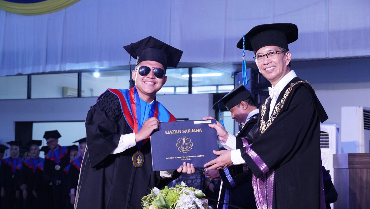 The handover of a diploma by ITS Rector to one of the graduates