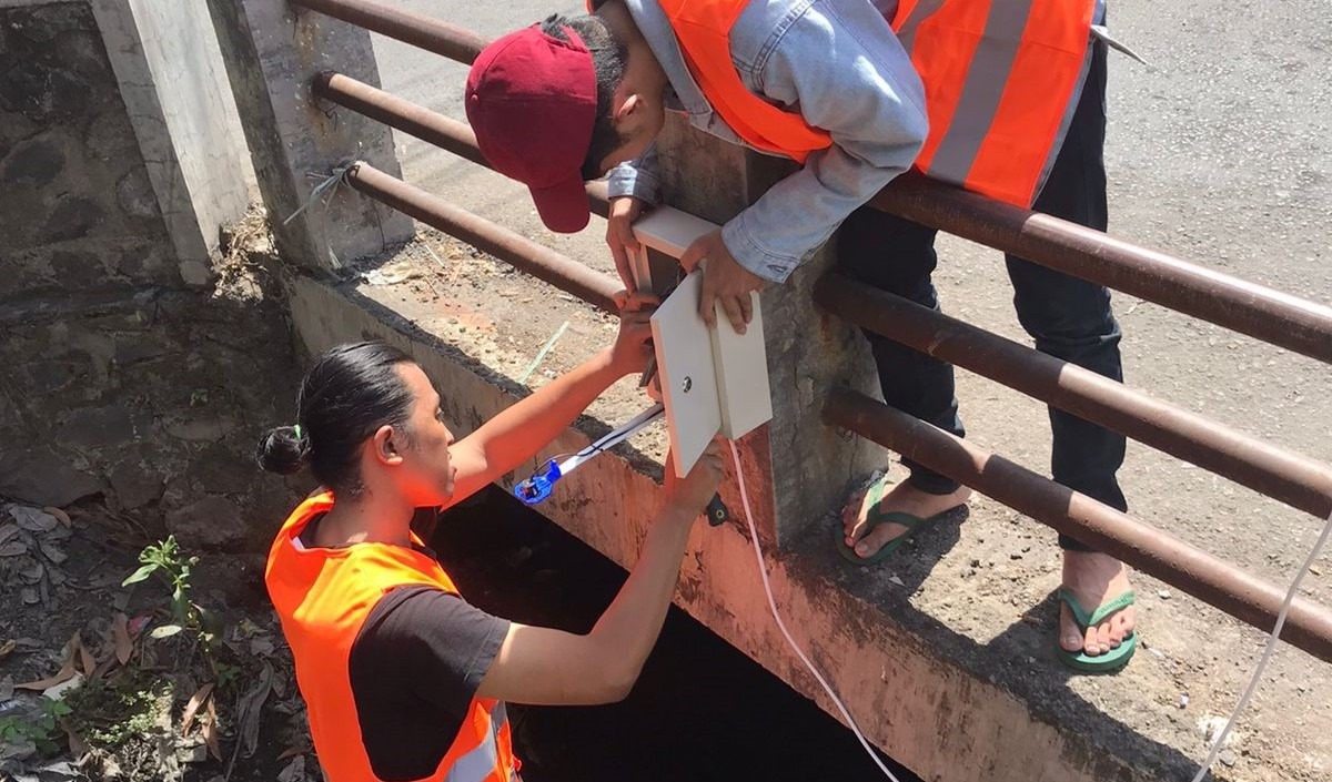 Pemasangan alat dan sensor AWLR oleh tim KKN ITS di salah satu saluran warga