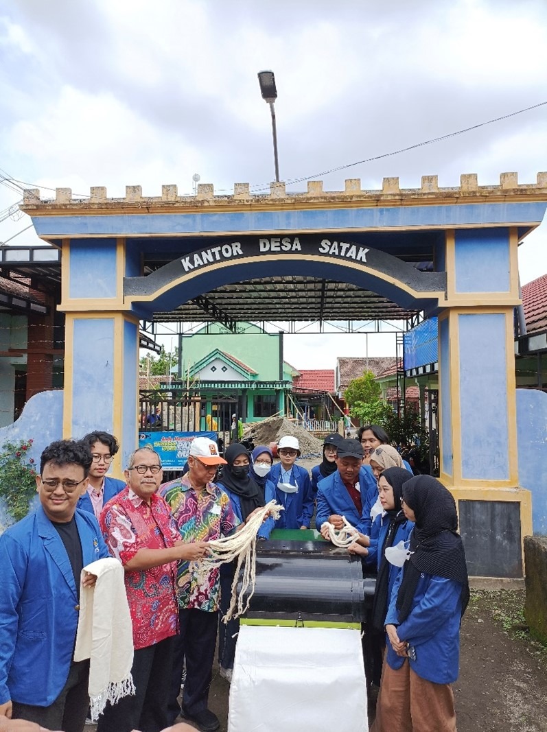 Tim KKN Abmas ITS ketika menjajal mesin pengolah serat daun nanas menjadi benang untuk produk tekstil di depan Kantor Desa Satak, Kabupaten Kediri