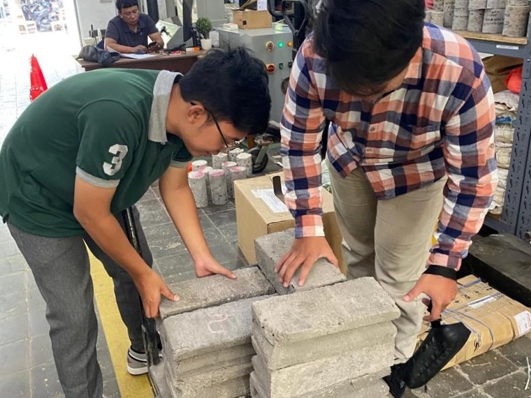 Gambar Tim KKN Abmas ITS sedang melakukan uji tekan batako