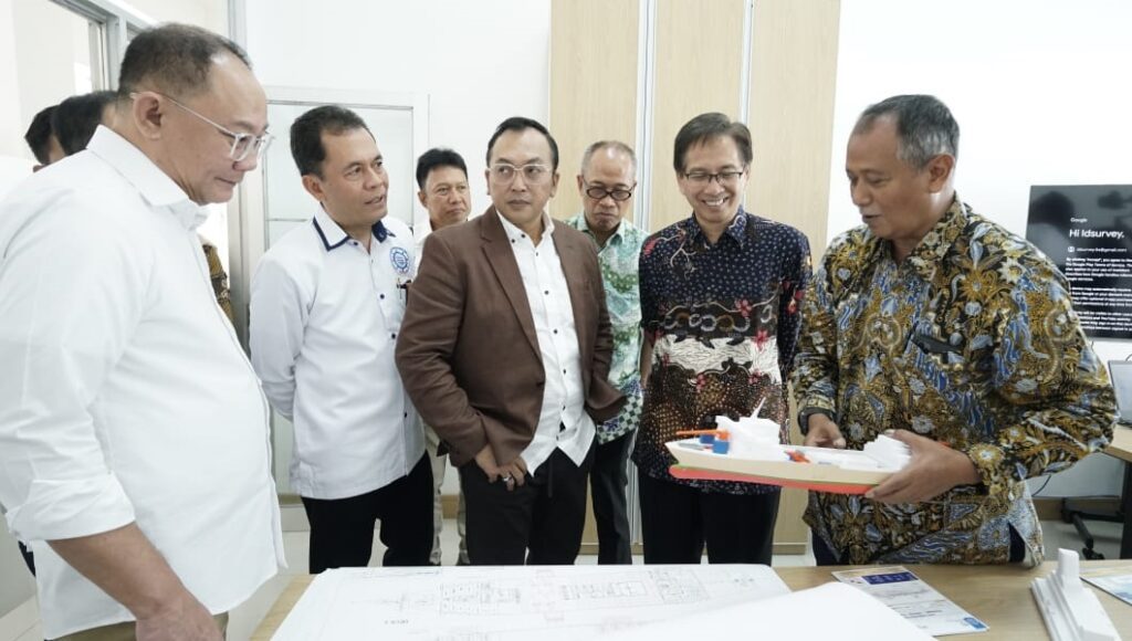 Manajer Unit Klaster Inovasi Maritim ITS Ir Tri Achmadi PhD (kanan) menunjukan salah satu prototype kapal karya ITS kepada para pejabat ITS dan undangan lainnya