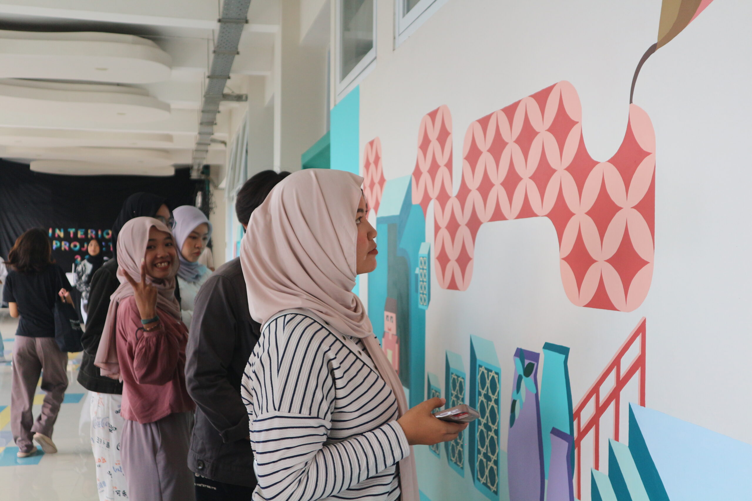 Gambar Mahasiswa Desain Interior menikmati karya mural Interior Project 2023