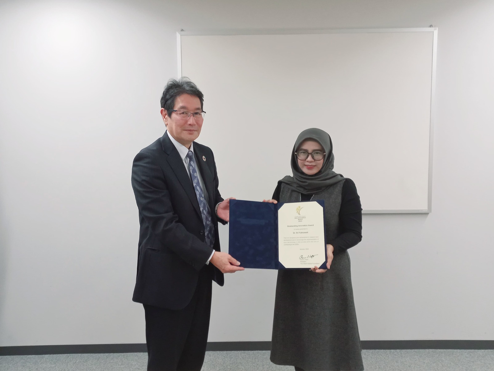 Managing Director Hitachi Global Foundation Teruya Suzuki (kiri) menyerahkan penghargaan kepada peneliti ITS Sri Fatmawati SSi MSi PhD di Jepang