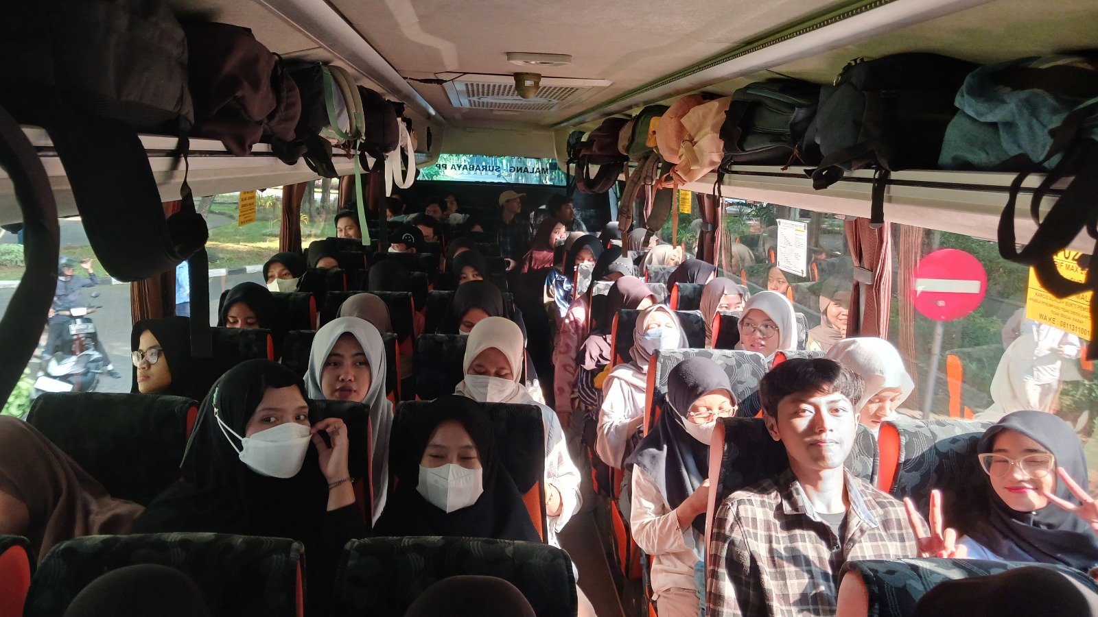 Para mahasiswa yang mengikuti Mudik Gratis ITS 2024 di dalam bus rute Nganjuk - Madiun - Ponorogo - Pacitan